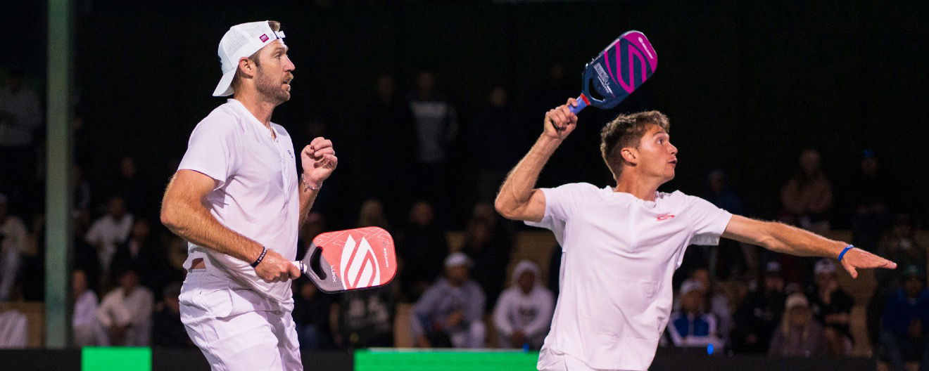 Shick takes a high ball alongside Sock in men's doubles