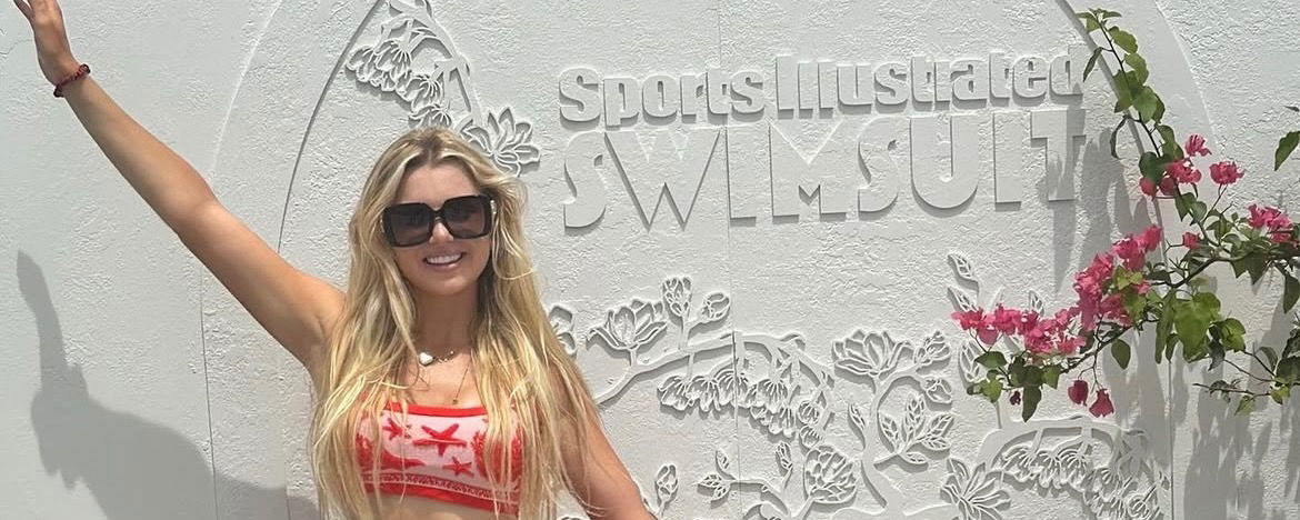 Anna Leigh Waters posing in front of a Sports Illustrated Swimsuit sign