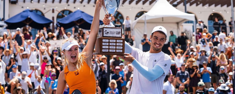 Anna Leigh and Ben holding up a trophy together. 