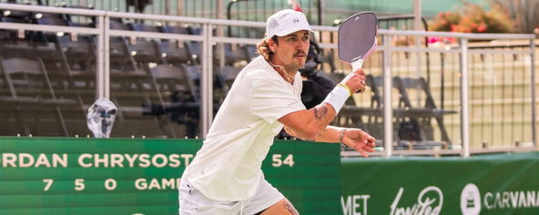 Michael Loyd playing pickleball in an all-white fit.