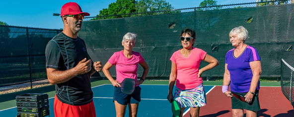 A coach and players on the court.