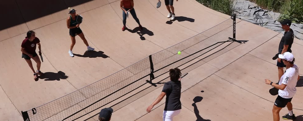 Connor Garnett and Allyce Jones playing "PickleVert" with the a group of people.