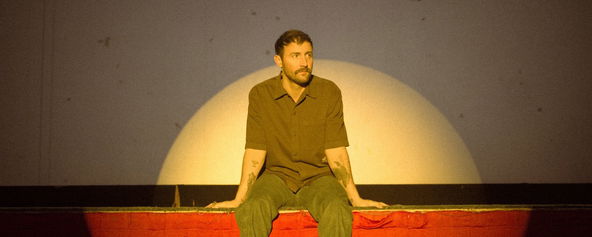 Ruston Kelly sitting on a stage.