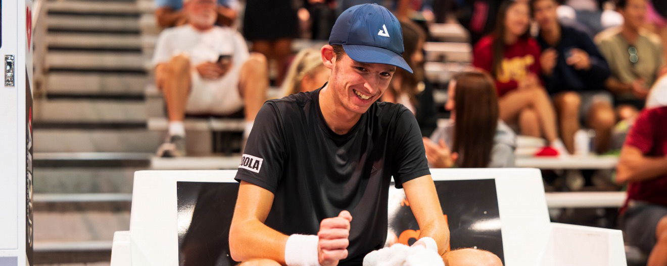 John Lucian Goins smling on the sidelines.