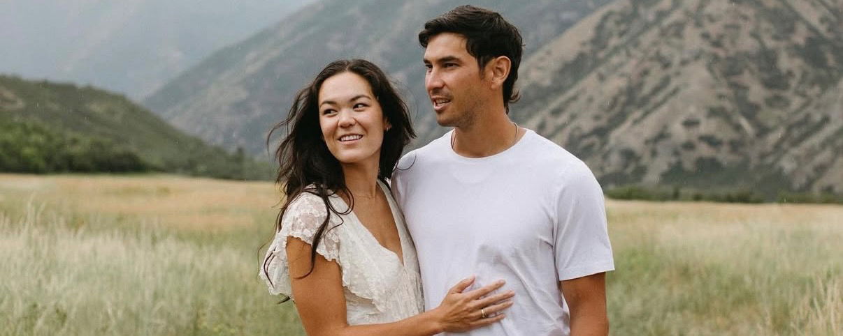 Brit and Tyler Loong in white, gazing out into the mountains.