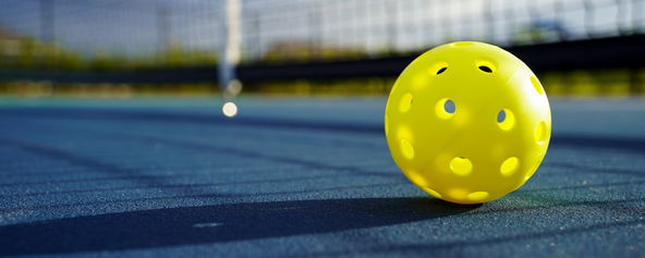 A pickleball on a pickleball court.