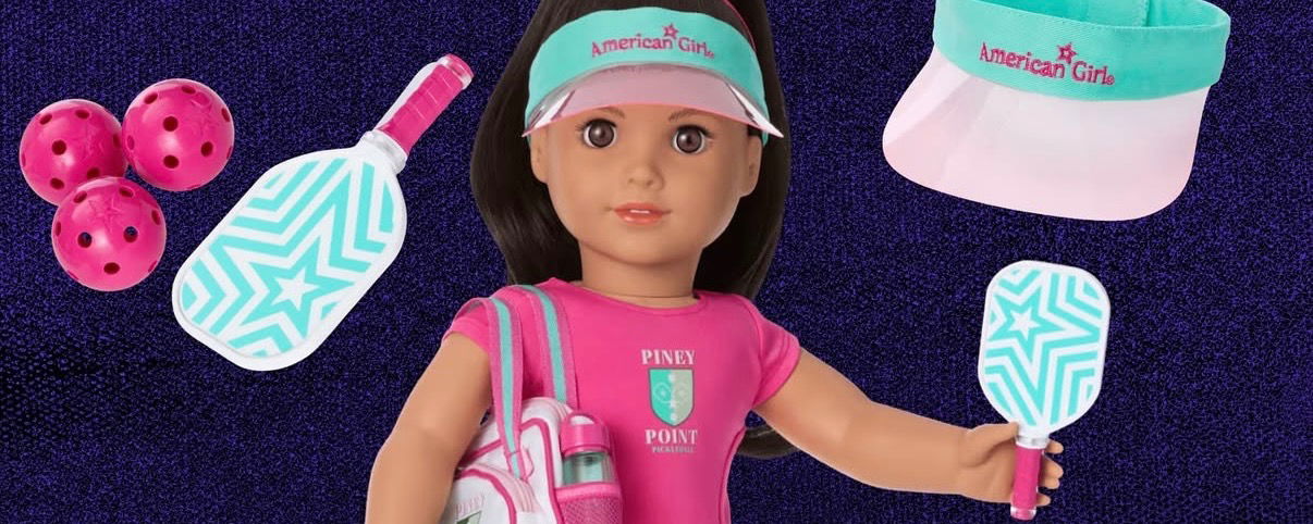 Raquel doll holding a pickleball paddle and wearing her pickleball outfit.