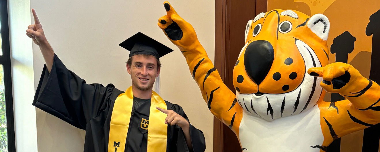 Dylan Frazier posing with Truman the Tiger, the official mascot of the University of Missouri. 