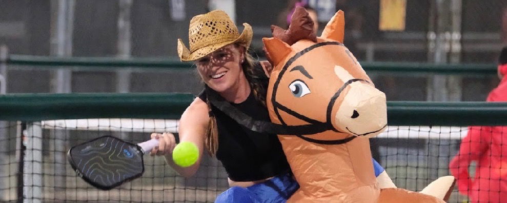 Mary Brascia playing inflatable pickleball while dressed as a cowboy.