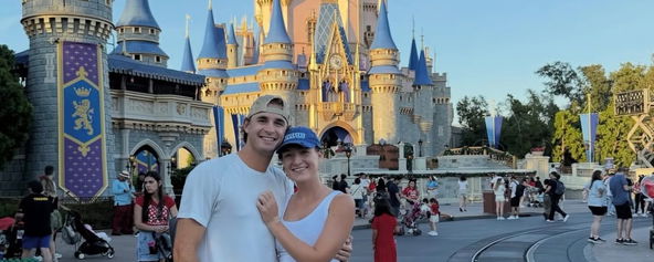 Nick Black and Maggie Brascia standing in front of Cinderella's Castle.
