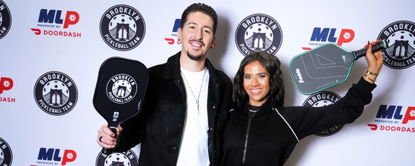 Hunter and Tara Fieri smiling with paddles in their hands.