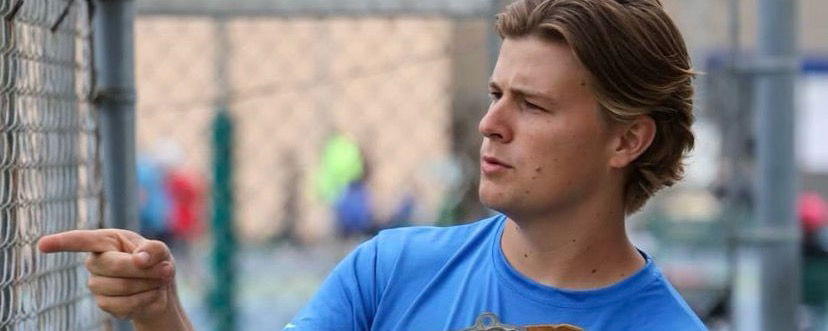 Blake Rutledge pointing near a pickleball court.