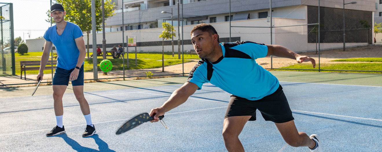 Two players on a court playing pickleball.