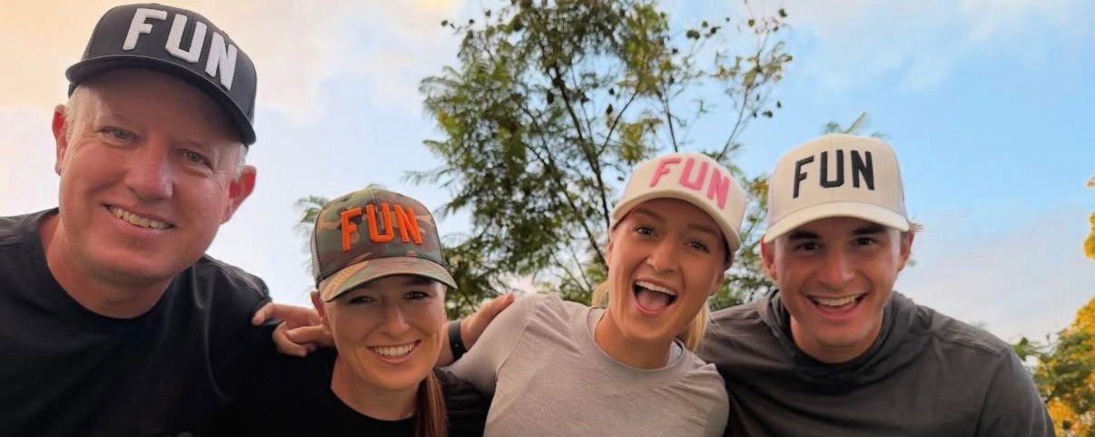 Vinnie, Mary, Maggie, and Nick with their arms around each other wearing matching hats.