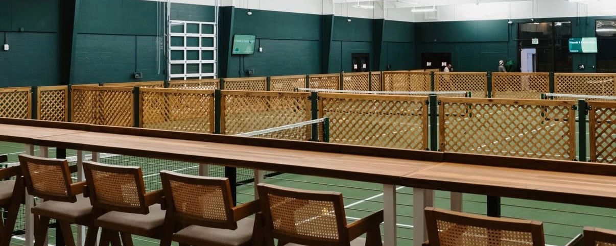 Chairs overlooking a pickleball court at St. Pete Athletic.