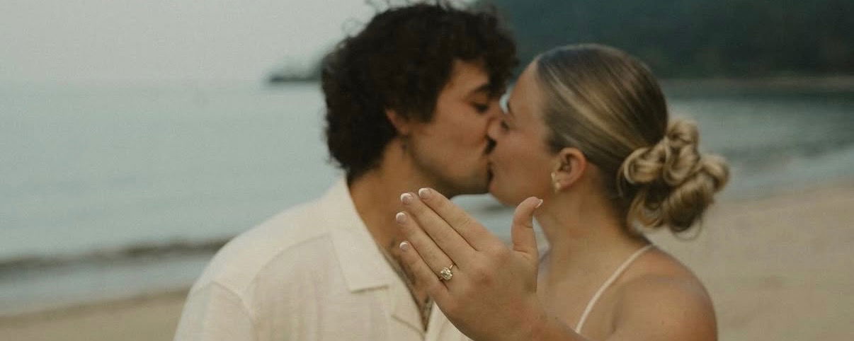 Michael Loyd and Juliet Steinhauer kissing with a ring on her wedding finger.