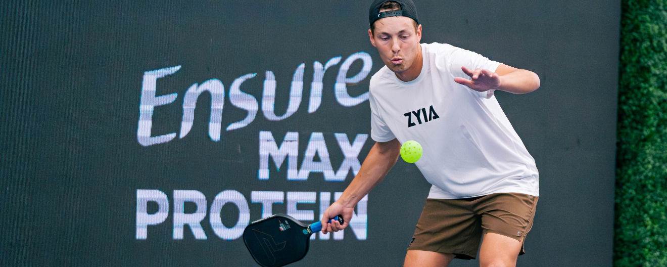Connor Garnett hitting a pickleball serve.