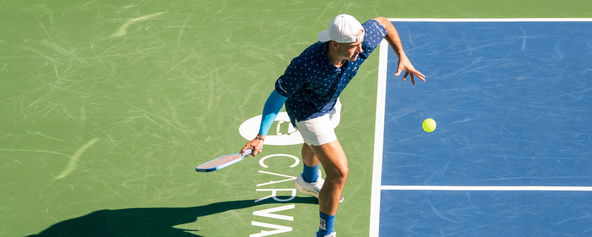 Alex Crum hitting a pickleball serve.