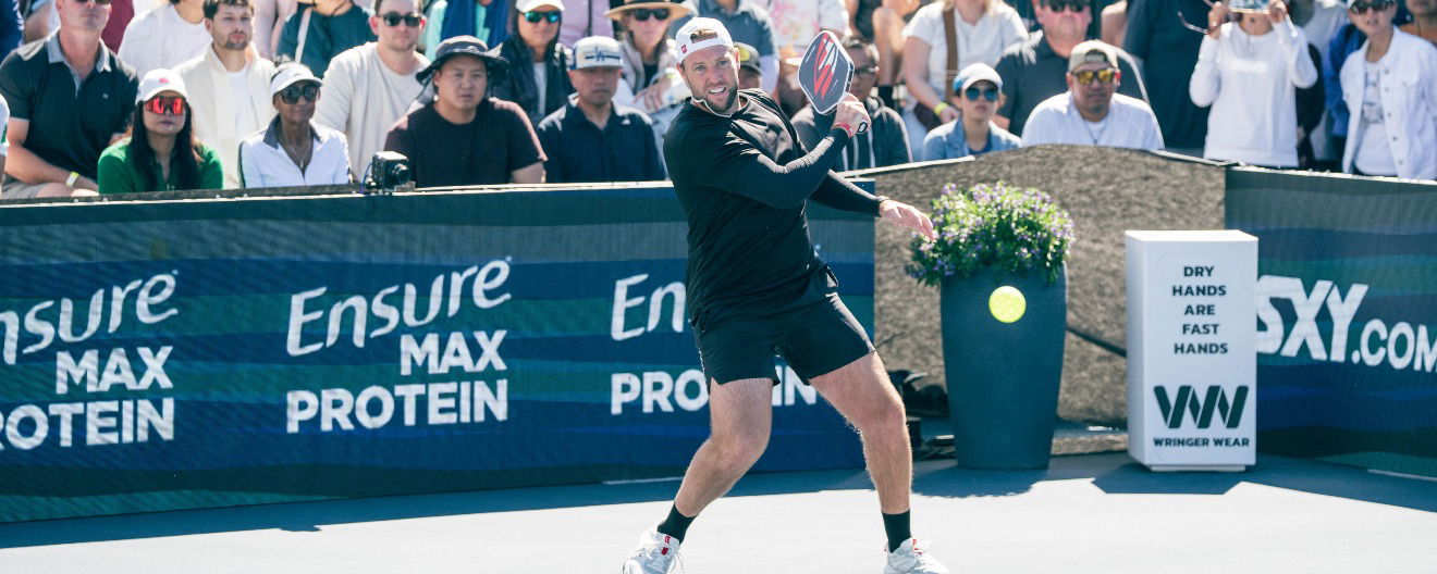 Jack Sock hitting a return at a tournament.