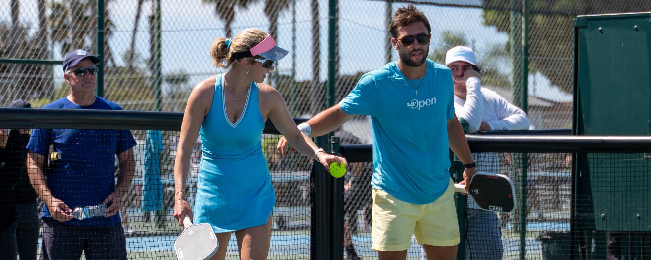 Audrey and Connor wearing light blue outfits playing pro pickleball.