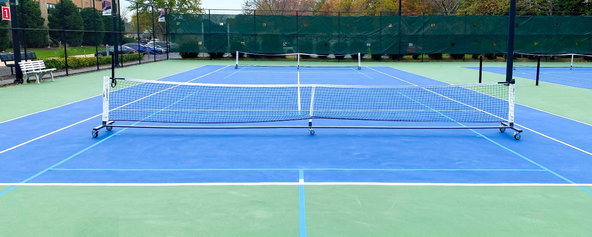 A tennis court with pickleball nets and pickleball lines.