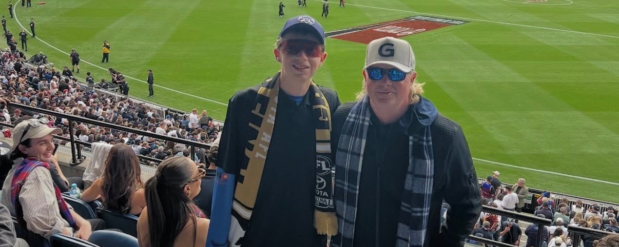 CJ and Darrin Klinger in the stands at a pro rugby game.