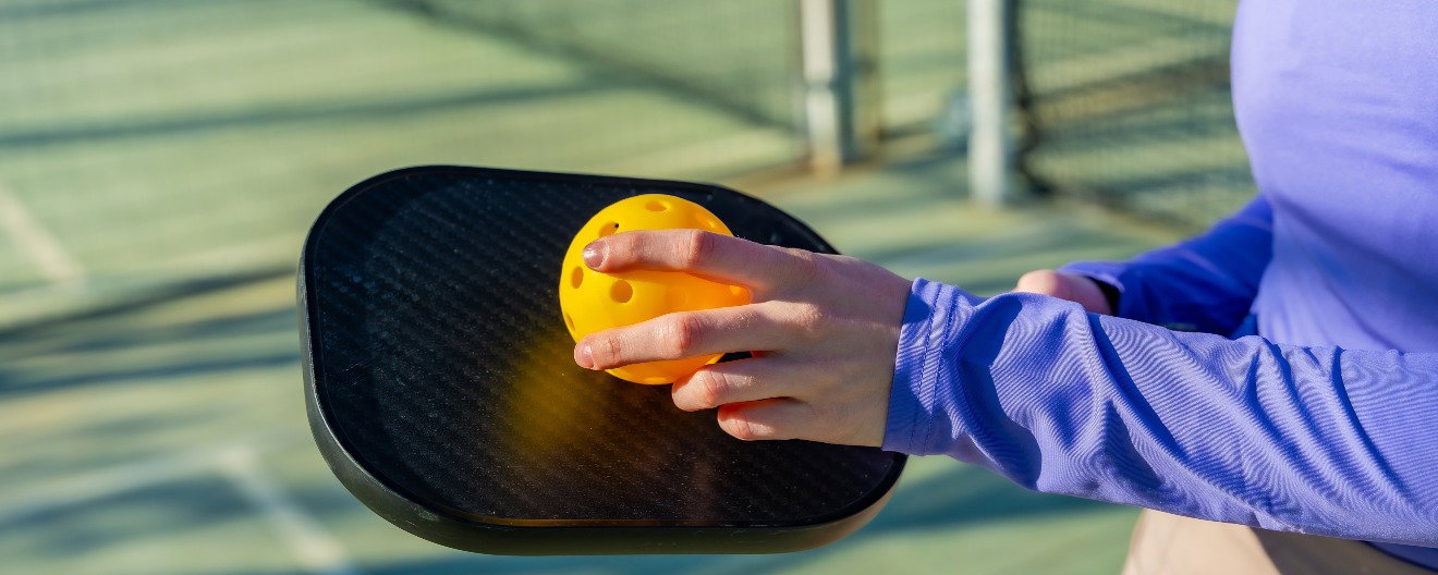 A pickleball player preparing to serve.