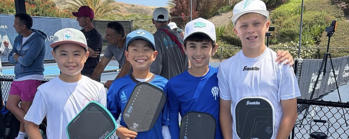 Four Junior PPA players smiling with their arms around each other.