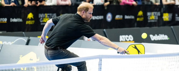 Prince Harry, Duke of Sussex hitting a backhand on the pickleball court.