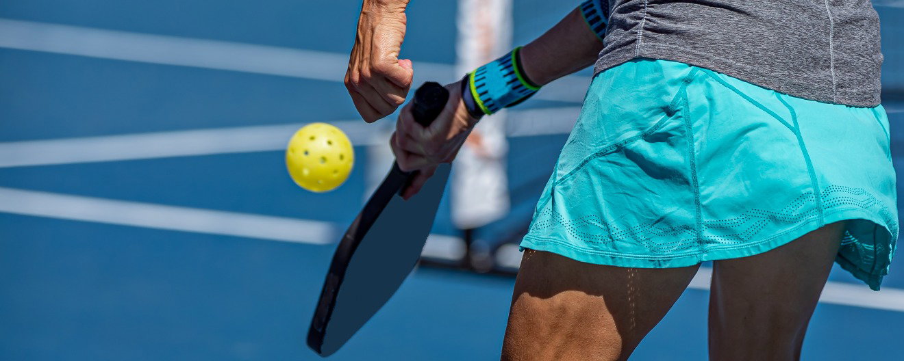 A female pickleball player preparing to hit a pickleball.