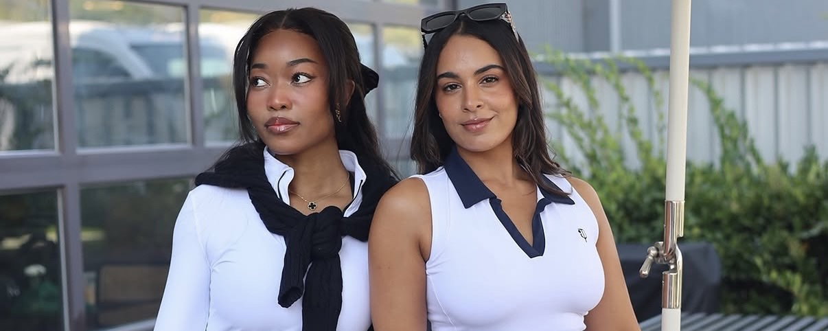 Two girls wearing the women's regatta quarter zip and hamptons polo in white