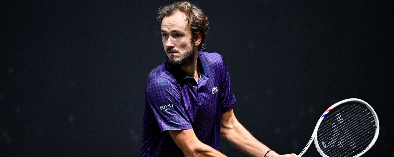 Daniil Medvedev preparing to hit a return on the tennis court.