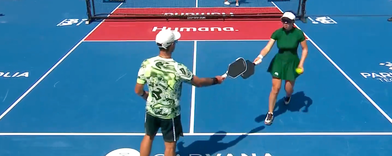 JW Johnson tapping Jorja Johnson's paddle while wearing a bright green and white swirly shirt.
