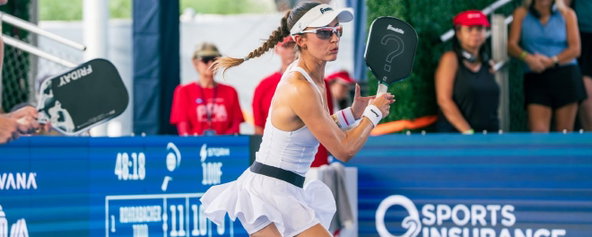 Parris Todd in a white tank top and flowy white skirt with a black waist band.