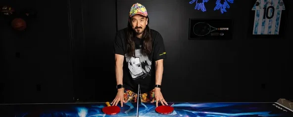 Steve Aoki standing near a ping-pong table.